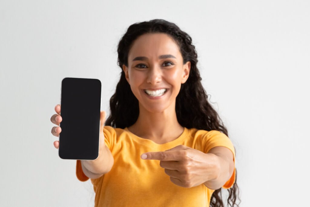 woman pointing to her phone happy that her website is mobile friendly