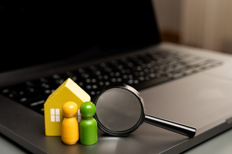 House, family and magnifying glass on laptop keyboard. The concept of searching for housing via the Internet. Find an apartment for rent online. Property valuation and realtor services