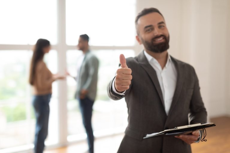 Real Estate Business, Sale and People Concept. Portrait of happy smiling realtor or businessman with clipboard showing thumbs up gesture, selective focus. Customers rejoice purchase