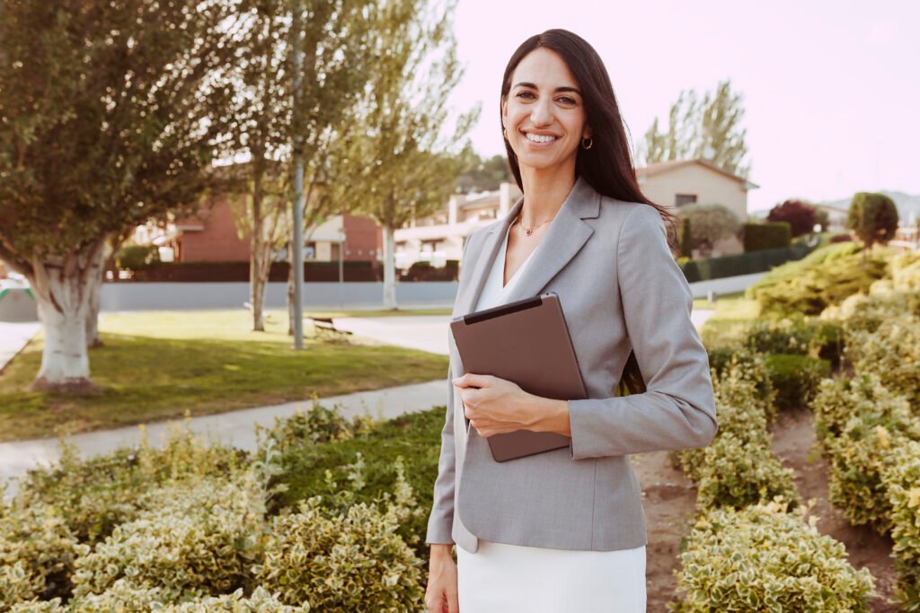 Portrait of urban happy real estate agent woman holding and using tablet computer and working. Technology, business, digital tablet concept.