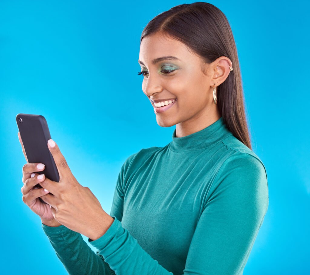 Woman, smile and typing on phone in studio for communication, social media or mobile app. Gen z mod.