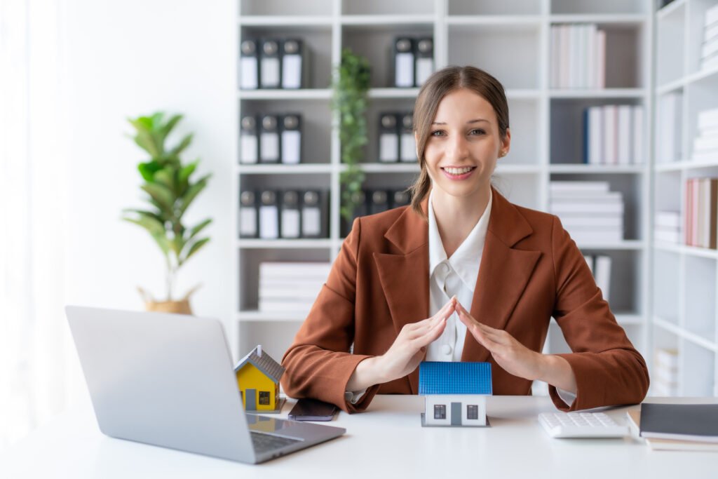 Agent female home sales and insurance sitting with laptop in office