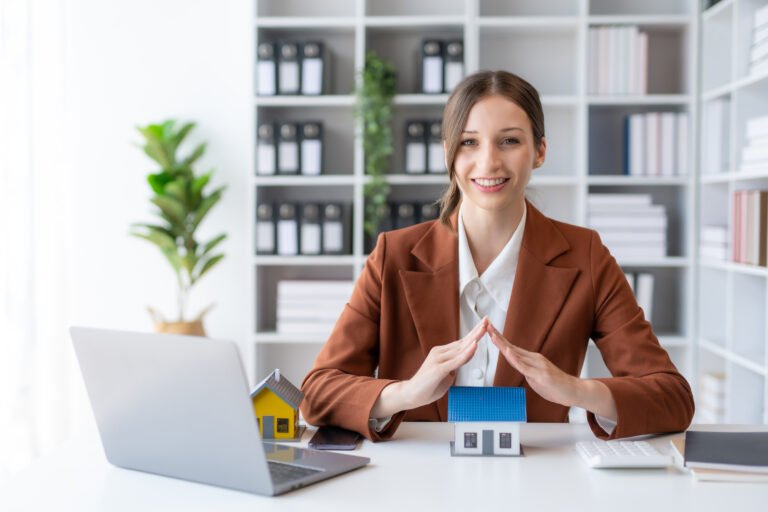 Agent female home sales and insurance sitting with laptop in office